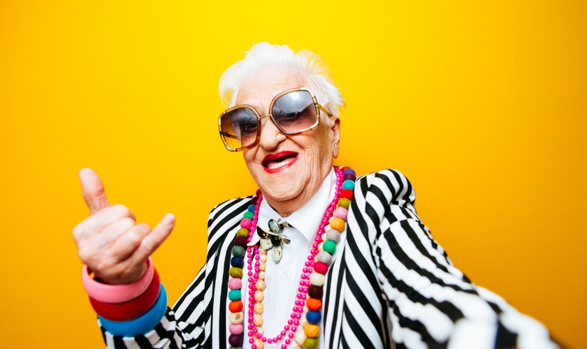 ältere Frau, bunt gekleidet mit großer Sonnenbrille